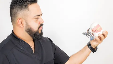 Odontólogo de Centro Estético Dental con un modelo anatómico dental