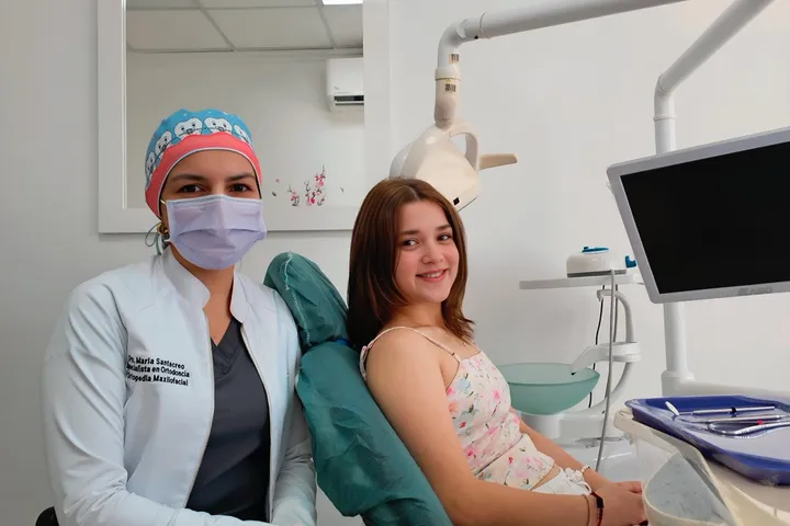 Especialista en ortodoncia con una paciente en el sillón dental
